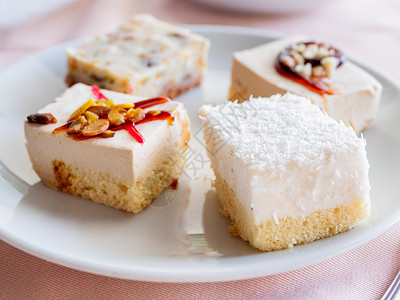 糕点片白色的盘子满是不同的糕点 美味的甜点加调味料 椰子片糖浆蛋糕配料食物椰子时间咖啡店坚果饼干馅饼背景