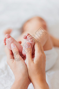母亲手握新生婴儿的赤脚 小脚在女人手中女儿白色幸福女孩儿子女士父母家庭手指投标背景图片