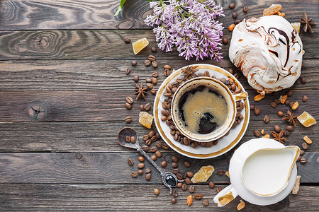 淡紫色星星质朴的木制背景 配有一杯咖啡 牛奶 巧克力蛋白甜饼和淡紫色的花 白色复古餐具和勺子 夏日早晨的早餐 顶视图 放置文本背景