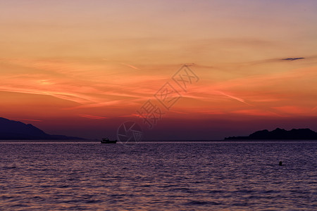 在科林斯湾美丽 充满活力的日落背景下 一艘海船沿着海岸线的地平线行驶的轮廓背景图片