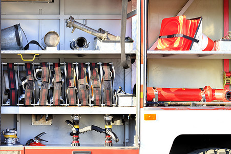 工程消防素材消防水龙头 阀门和起重机 交通锥子都位于设备齐全的消防车货舱内背景