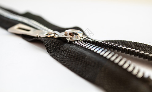金属开合拉链黑色棉布材料扣子织物紧固件联盟衣服纺织品牙齿背景图片