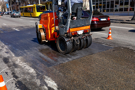 在城市街道上修路段时 横跨橙色道路的滚轮背景图片