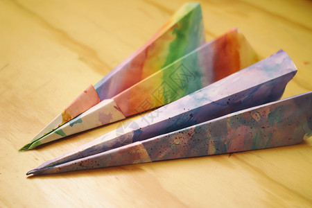 木制桌上纸质彩色平面玩具飞机折纸桌子木头背景图片