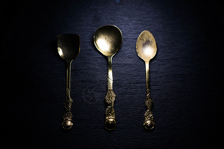 黑色背景上的经典叉子和勺子反射桌子厨房渲染用餐饭馆餐厅金属金子午餐背景图片