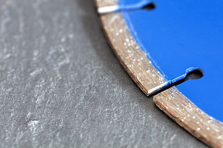 灰色混凝土背景的钻石切割盘片段车轮力量金属铺路宏观产品硬件刀具工具调子背景图片