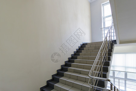 高楼楼楼层之间内部楼梯的阶梯石头地面办公室楼梯间脚步出口建筑金属白色栏杆背景图片
