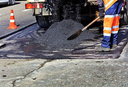 修建公路的建筑铺设了新的沥青 并修复了道路的一部分背景图片