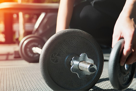 妇女用手在健身房的肌肉结构中安装钢铁哑铃男人重量白色身体运动员黑色锻炼男性健美女性背景图片