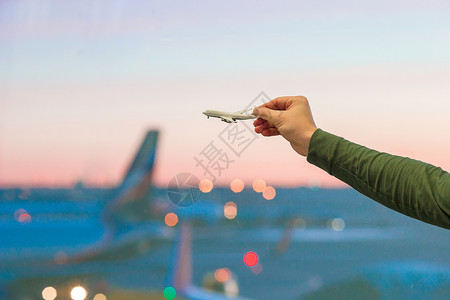 握着飞机型号的近手飞机场空气货物玩具天空公司航空公司翅膀客机套装背景