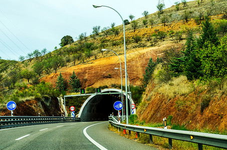 高速公路隧道通向隧道 穿过山顶的隧道的快路蓝色路线基础设施沙漠技术岩石国家运输旅游全景背景