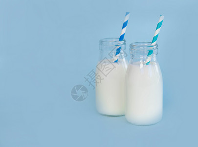 瓶装鲜奶水 以浅蓝色背景的稻草 食物h饮食早餐玻璃奶制品蓝色白色液体瓶子背景图片