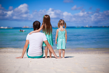 水孩子暑假期间在白沙滩上 两个女孩和小爸爸的幸福家庭太阳镜孩子情调父母热带女儿海滩婴儿男人女孩背景
