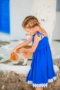 可爱的小可爱女孩在希腊村户外玩姜猫游戏高清图片