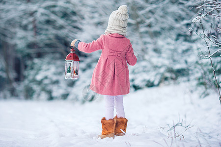 带座灯笼冬天带手电筒和蜡烛的可爱小女孩雪花童年闲暇喜悦展示围巾享受降雪森林新年背景