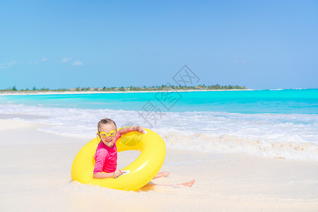 快乐的孩子与充气橡皮圈 在海滩上玩得开心假期微笑运动闲暇太阳镜海岸橡皮戒指海岸线热带背景图片