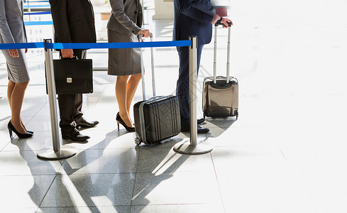 商业人士排队在机场办理报到手续商务女士商界手提箱乘客行李男人飞机场女性会议背景图片