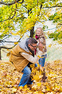 成年夫妇在公园里玩木叶的肖像背景图片