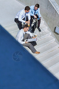 一群在休息期间制定业务计划时坐在楼梯上的英俊商务人士 他们正在准备商业计划会议男人风暴企业家次数男士设备下载办公室团体背景图片