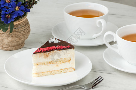 蛋糕和饮料盘子里的蛋糕和桌上的杯子白色桌子甜点棕色紫色糕点食物飞碟咖啡店饮料背景