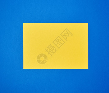 蓝色背景上空白的黄色 A4 纸背景图片