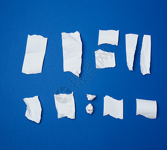 蓝色 ba 上的一组各种撕破的白色皱巴巴的纸背景图片
