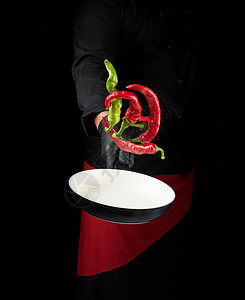孟子义穿黑色制服和红色围裙的厨师有一个圆锅 有新鲜绿色香料胡椒辣椒蔬菜菜单平底锅餐厅食物美食背景