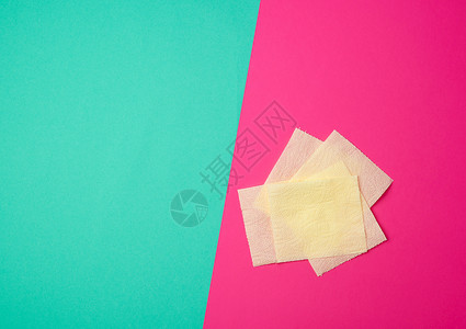 撕开的绿纸绿粉色背景上的几张柔软的黄色卫生纸背景