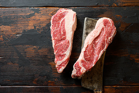 大理石纹黑安格斯牛肉放在切肉刀上 有机农场牛仔牛肉 深色背景 顶视图 复制空间背景图片