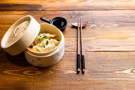 蒸食中国小吃 中国蒸饺 中国传统美食概念 在木制蒸锅酱油和筷子侧视图空间中用于文本背景