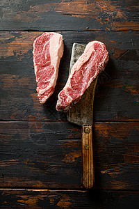 切肉刀上的大理石纹黑安格斯特级牛肉 有机农场牛仔牛肉 深色背景 顶视图 复制空间背景图片