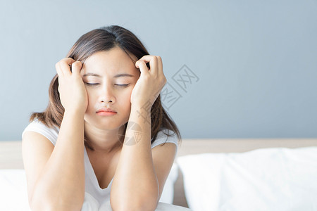 睡在卧室的闭合女人 与沮丧的感觉坐在床上女孩思维压力悲伤女性夫妻失眠背景图片