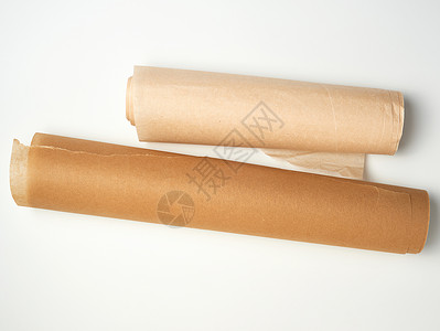 两卷棕色纸纸 用于在白色背面烘烤烹饪床单羊皮纸蜂蜡厨房黄色用具滚动工具食物背景图片