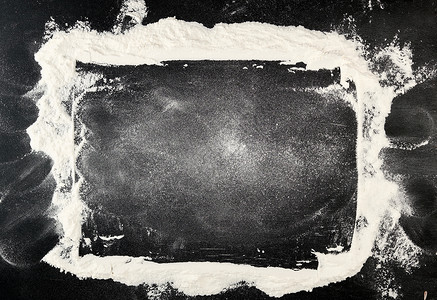 面粉框架散落在黑桌上的白小麦面粉糕点白色木头黑板边界蛋糕框架黑色食物面包背景