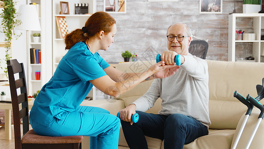 女护士帮助一个老人做早锻炼的年长者保健卫生救助残障治疗师女性病人人士老年医生背景图片