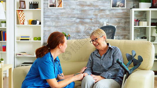女护士与老年妇女和阿尔茨海默人交谈女性女士帮助退休看门人关爱社工老年人成人微笑背景