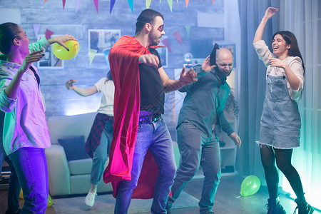 超级聚惠一群朋友在聚会上享受他们的时间微笑运动音乐啤酒气球戏服男人派对房间超级英雄背景