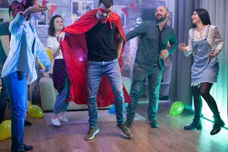 超级聚惠穿着超级英雄服装的年轻人享受微笑运动友谊音乐酒精快乐女性派对乐趣背景