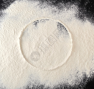 面粉上洒满的白面粉 从筛选处取回圆印黑色烹饪桌子食物面包面团木板白色空白蛋糕背景