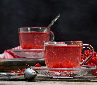 在透明杯子里的热生茶 手柄和碟子芳香药品勺子水果飞碟木头荚蒾桌子果汁食物背景图片