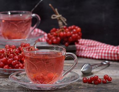 在透明杯子里的热生茶 手柄和碟子桌子芳香食物浆果飞碟药品饮料水果勺子玻璃背景图片