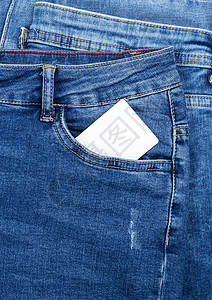蓝色牛仔裤口袋里的空白纸卡背景图片