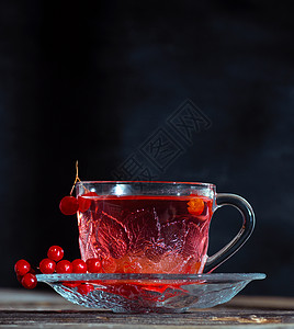 在透明的杯子里用手柄喝热生茶食物药品黑色草本红色飞碟玻璃桌子浆果饮料背景图片