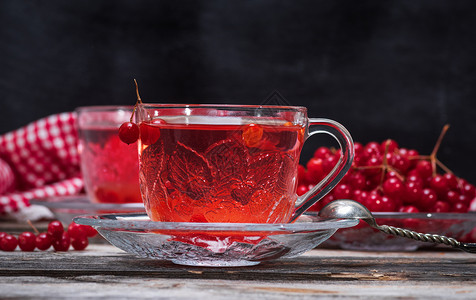 在透明的杯子里用手柄喝热生茶浆果红色药品饮料黑色玻璃食物木头飞碟勺子背景图片