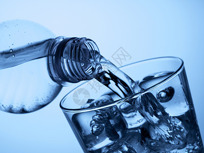 塑料瓶和加冰的玻璃杯茶点饮料立方体玻璃流动矿物蓝色气泡行动运动背景图片
