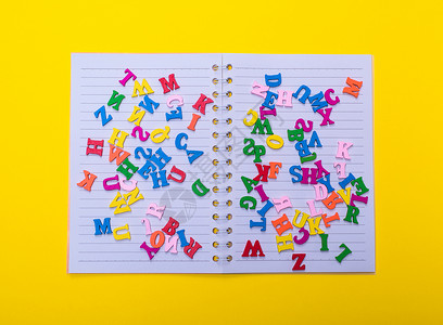 英文字母的多彩多姿的木制字母幼儿园白色写作字体英语学校知识教育笔记本黄色背景图片