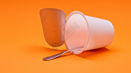 橙色背景的勺子空清酸奶杯早餐塑料牛奶厨房奶油薄片玉米橙子白色食物背景图片