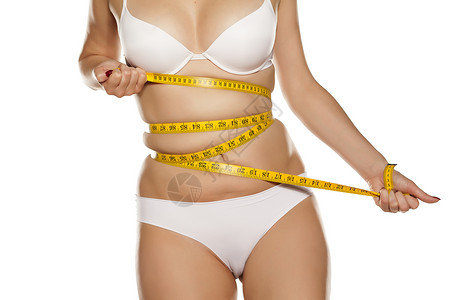 妇女用胶带测量腰部的尺寸背景图片