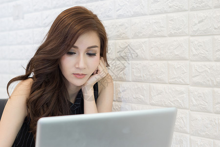 在办公室用笔记本电脑工作的年轻女商务人士的近身桌子白色人士商业女性商务技术成人背景图片