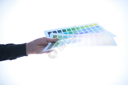 拿着颜色试卷桌的商务人士手 白背生产调色板职场墨水打印测试光谱创造力屏幕质量背景图片
